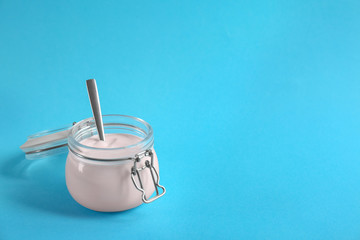 Jar with tasty yogurt on color background