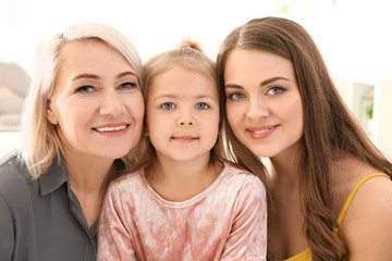 Happy young woman with her mother and daughter at home