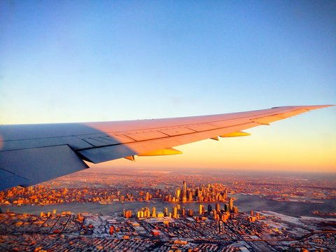 Scenic and impressive aerial view of the New York City Manhattan Skyline (USA) from an airplane during sunset / sunrise on a winter day