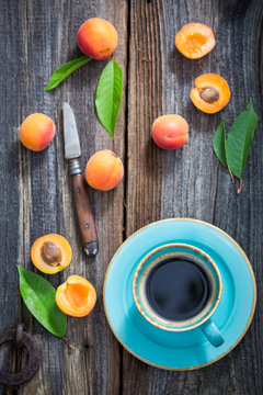 Blue coffee and orange plums on wooden tray