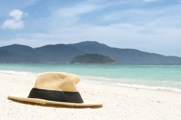 Beach hat on the sandy beach in the summer.