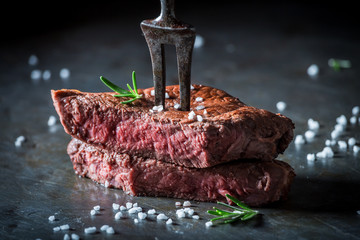 Nahaufnahme von Medium Rare Steak mit Salz und Kräutern