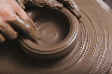 Hands working on pottery wheel
