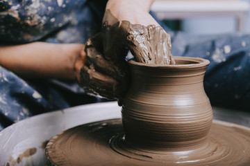 Hands working on pottery wheel