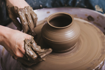 Hands working on pottery wheel