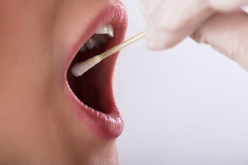 Dentist Taking Saliva Test Of A Patient