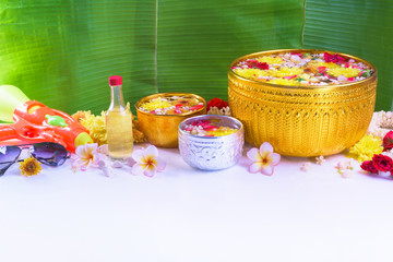 Thai traditional jasmine garland and Colorful flower in water bowls decorating and scented water, perfume, marly limestone, pipe gun for Songkran Festival or Thai New Year