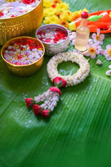 Thai traditional jasmine garland and Colorful flower in water bowls decorating and scented water, perfume, marly limestone, pipe gun on Banana leaf for Songkran Festival or Thai New Year