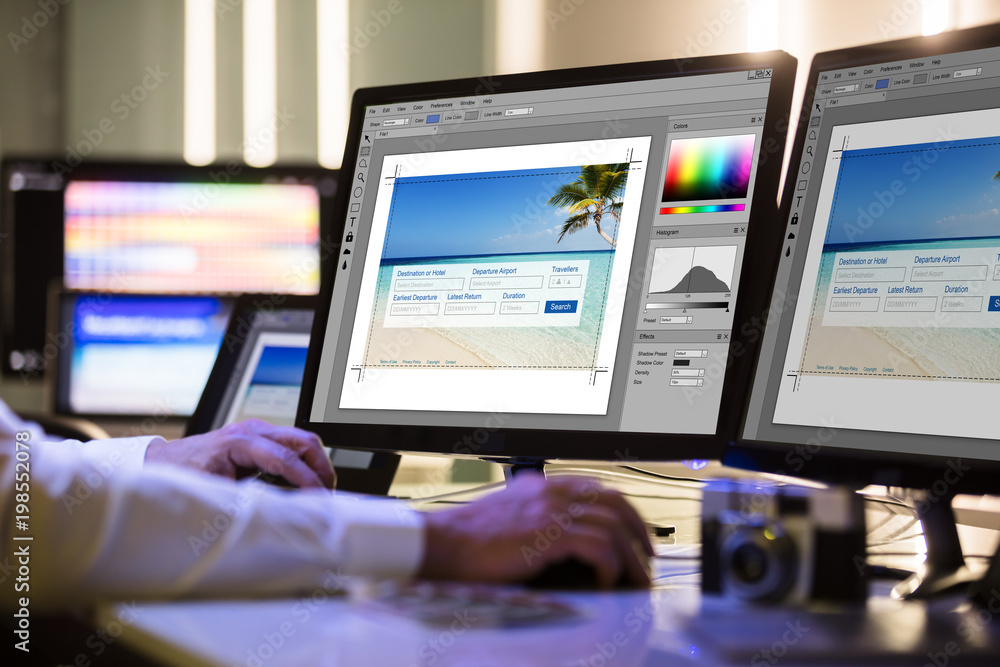 Poster Designer Working On Multiple Computer Screen