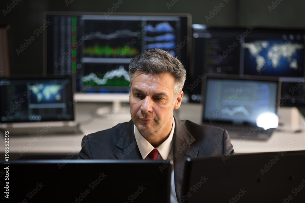 Poster stock market broker looking at multiple computer screen
