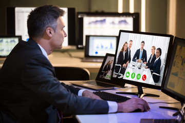 Businessman Video Conferencing With Happy Colleagues On Computer