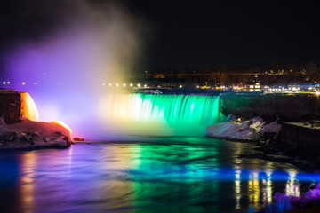 Fototapeta na wymiar Niagara Falls in spring time with green and orange lights