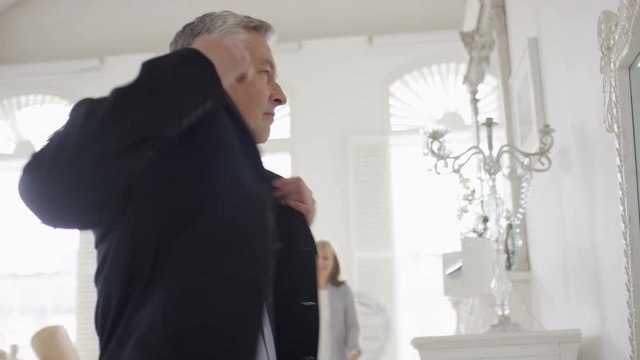Man getting ready in front of the mirror stands with his partner