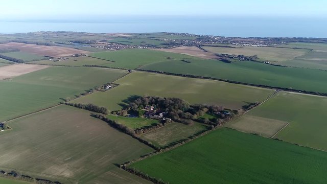 Aerial bird view flight over farm located at typical English countryside landscape in general this rural area or countryside is a geographic area that is located outside towns and cities area 4k