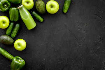 Greeny vegetable smoothie in bottle with cucumber, pepper, apple on black background top view mock up