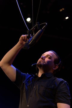 male theater technician hanging microphones