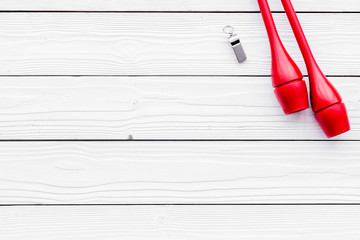 Maces for rhythmic gymnastics on white wooden background top view copy space