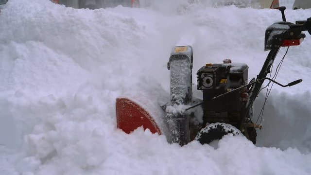Man with a snow blowing machine working