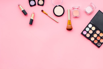 Decorative cosmetics for make up on pink desk background top view mock up