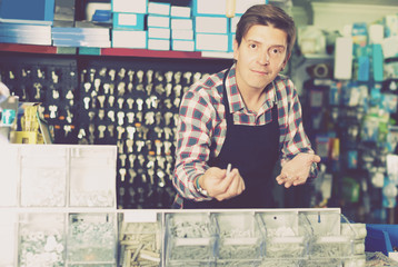 Worker man in hardware store is trading goods for construction