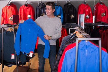 Nice man chooses clothes in shop