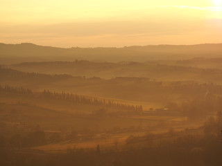 Obraz premium Sunrise in the lands of Tuscany. Warm colors on the hills and haze
