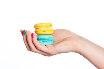 Female hand holding almond cookies on white background.