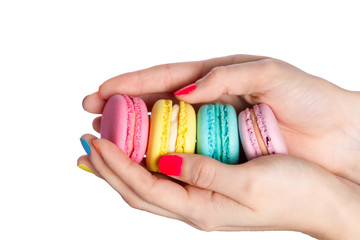 Female hand holding almond cookies on white background.