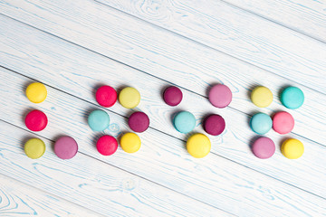 Bright Almond cookies are laid out on a light wooden background.