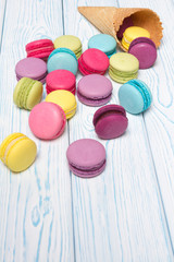 Almond cookies crumbled from waffle cone on light wooden background