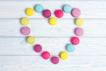Bright almond cookies laid out on a light wooden background in the form of heart