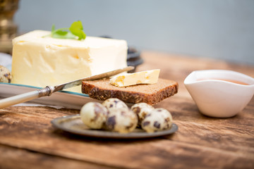 A piece of bread with butter on wooden background