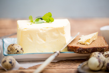 A piece of bread with butter on wooden background