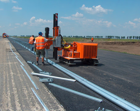 Road Worker Mounting The Roadside Guardrail