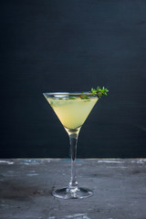 Tasty bitter cocktail with thyme in martini glass. Selective focus.