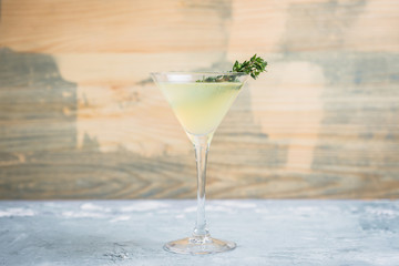 Tasty bitter cocktail with thyme in martini glass. Selective focus.
