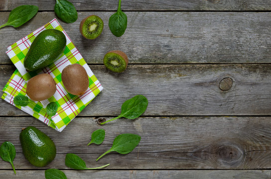 Avocado, kiwi, spinach on wooden background