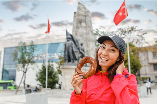 Happy woman eating traditional turkish simit bread bagel in Istanbul, Turkey