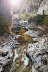 a deep gorge with a river in the mountains of Italy.