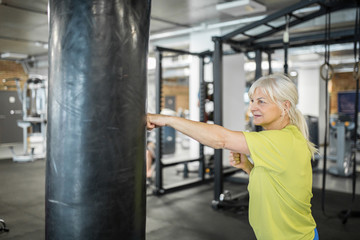 Senior woman enjoying training on punching bag