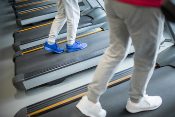 People legs walking on treadmill at gym