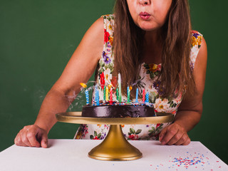Senior woman blowing out candles. Party, congratulation concept.