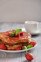 Pancakes with fresh strawberries and jam.