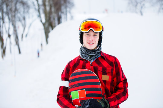 Photo of athlete in helmet with snowboard on blurred background