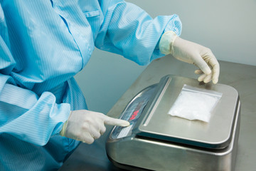 woman weighing chemicals on scale at pharmaceutical factory, .Cough syrup