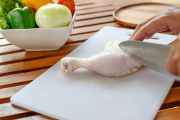 Fototapeta na wymiar Chef cutting chicken for cooking