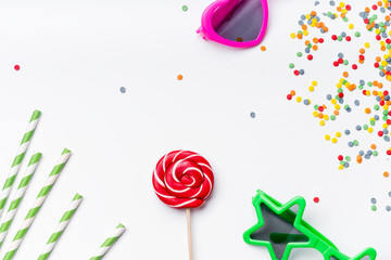 Flat lay with various colorful party accessories on white background with copy space