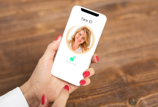 Woman using mobile phone's facial recognition technology