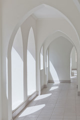 empty abstract light interior corridor background with arches and sunlight