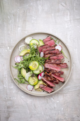 Traditional barbecue skirt steak sliced with salad and avocado as close-up on a plate with copy space